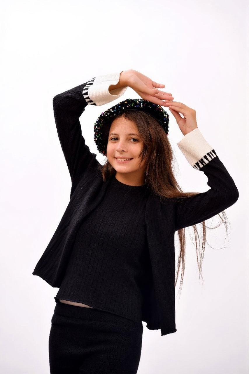 ribbed black top paired with a matching open-front cardigan